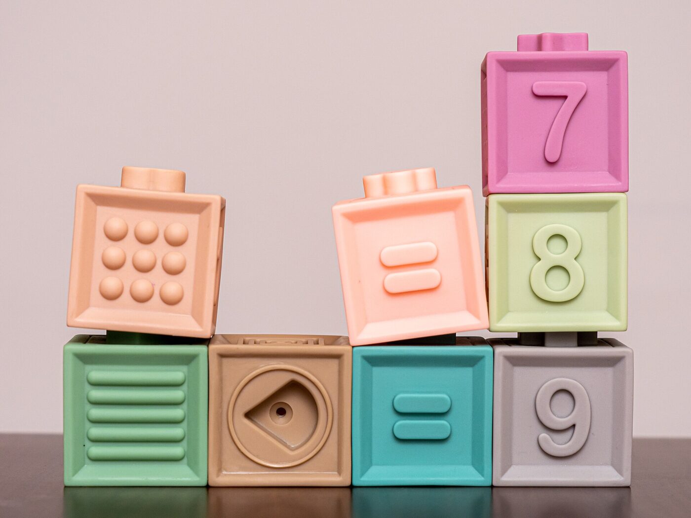 Close-up of colorful plastic building blocks stacked together, several blocks printed with numbers.
