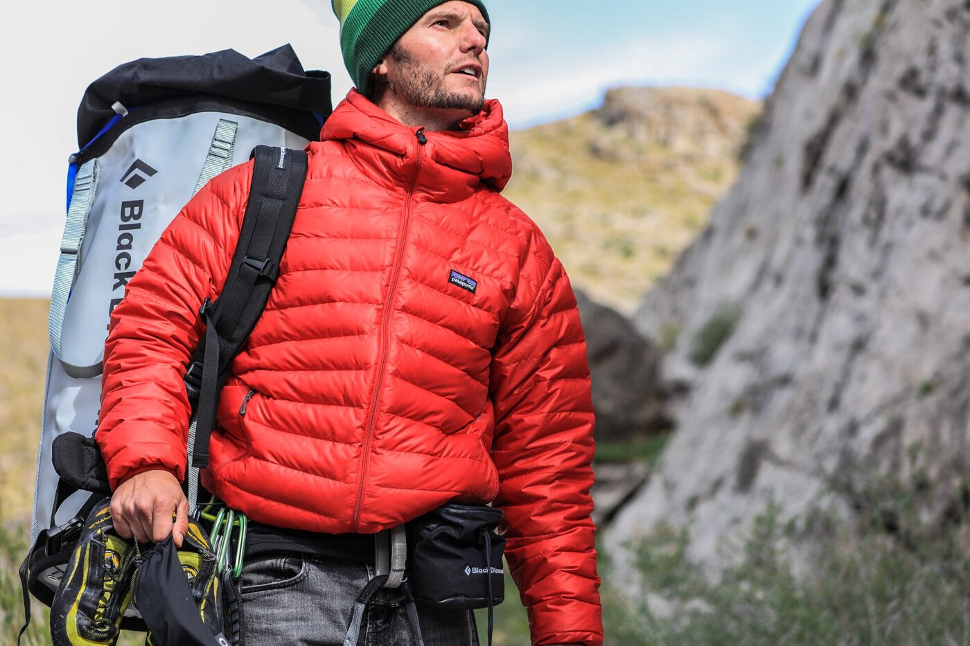 A hiker wearing a red waterproof shell jacket, the fabric clearly visible.