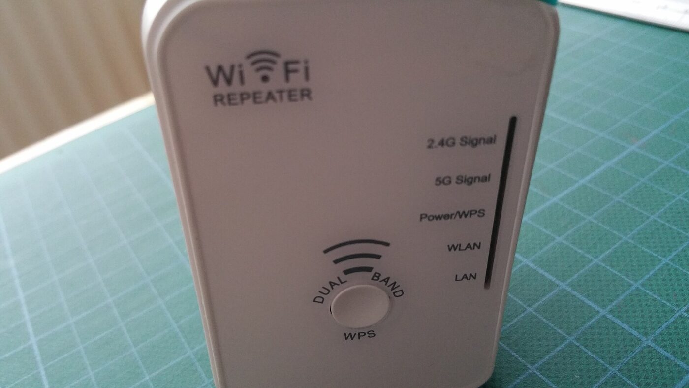Front view of a white plug-in Wi-Fi extender labeled 'Wi-Fi Repeater' with indicator lights for 2.4G, 5G, power and WLAN, and a dual-band WPS button.