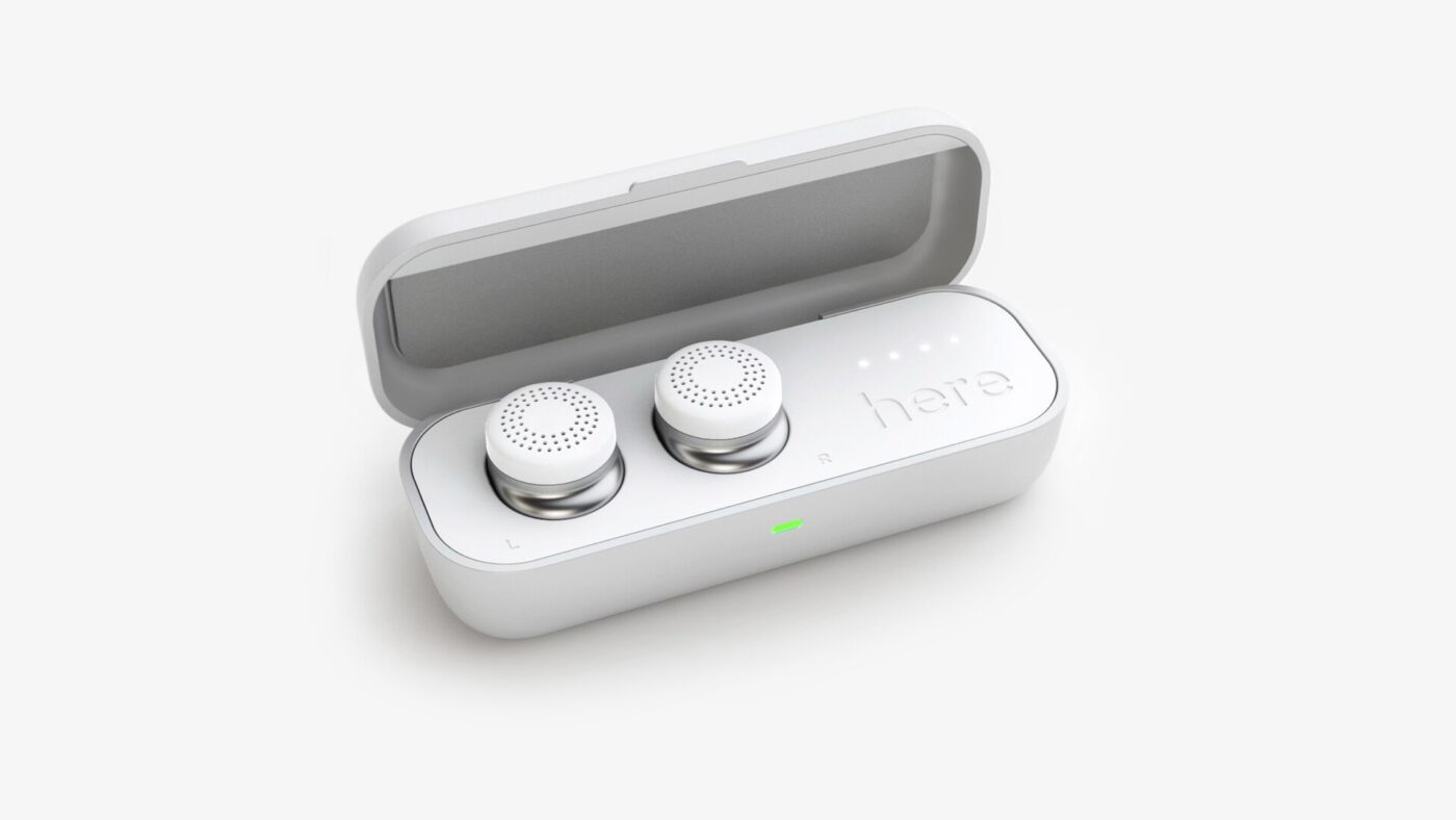Two true wireless earbuds resting in their open white charging case.