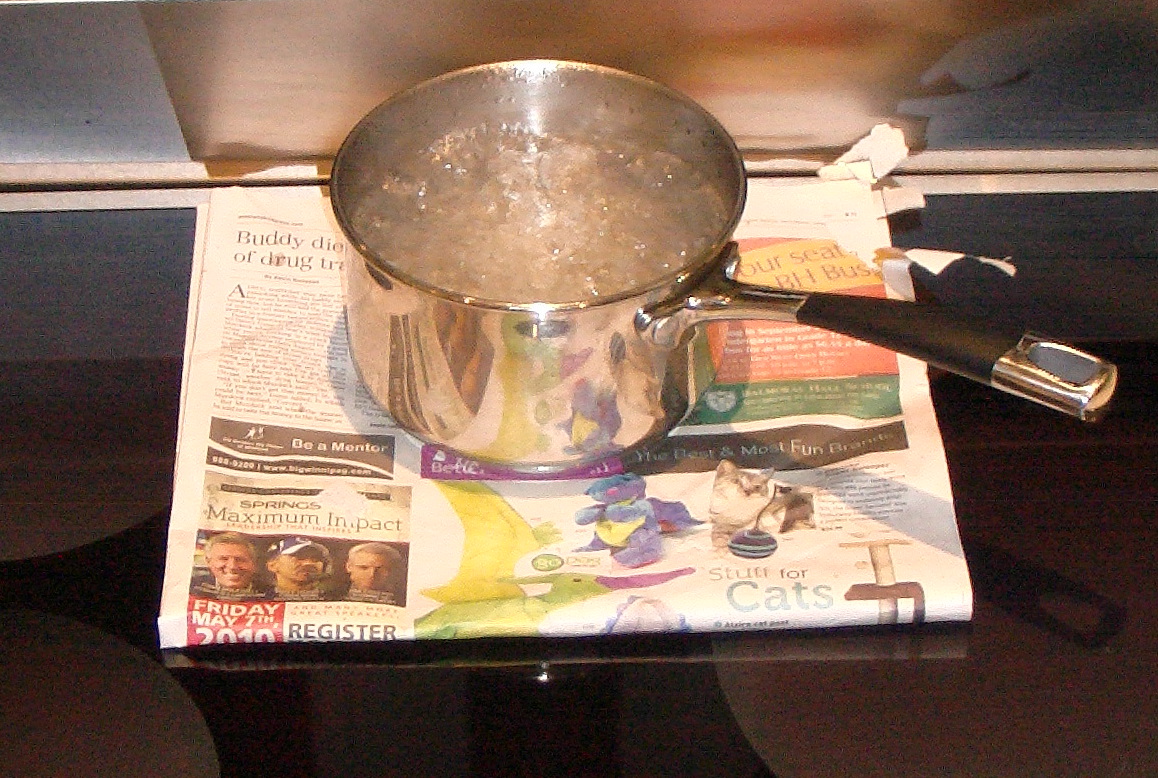 A pot boiling on a glass induction cooktop