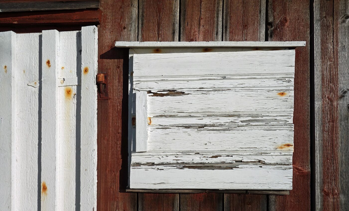 White paint flaking from a wooden hatch