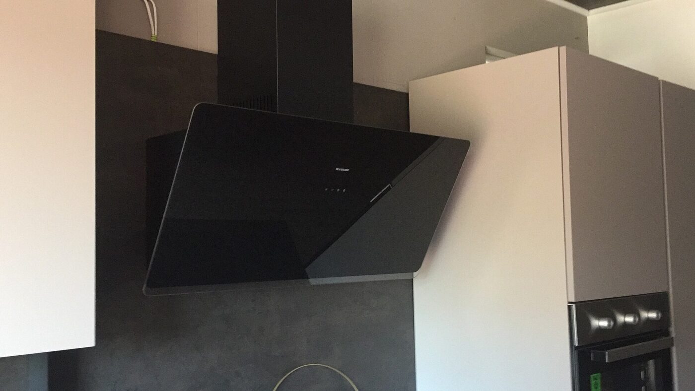 A stainless steel chimney range hood above a kitchen counter