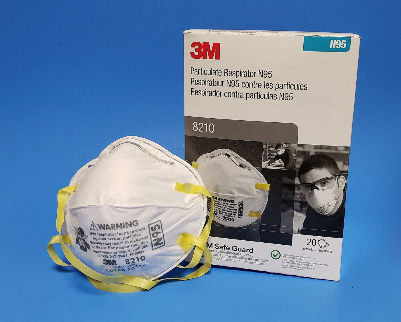 An N95 filtering facepiece respirator beside its box